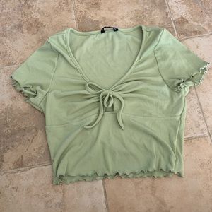 Pale green cropped frilly tie top